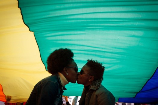 A couple kiss under the rainbow flag dur